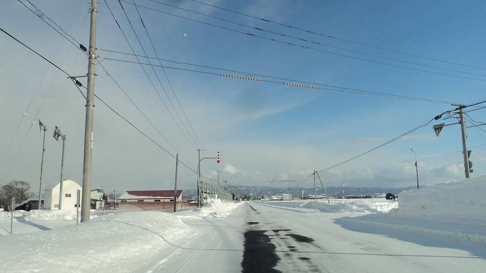 雪の残る道路。冬は見通しや路面状態に合わせた移動計画が必要です。