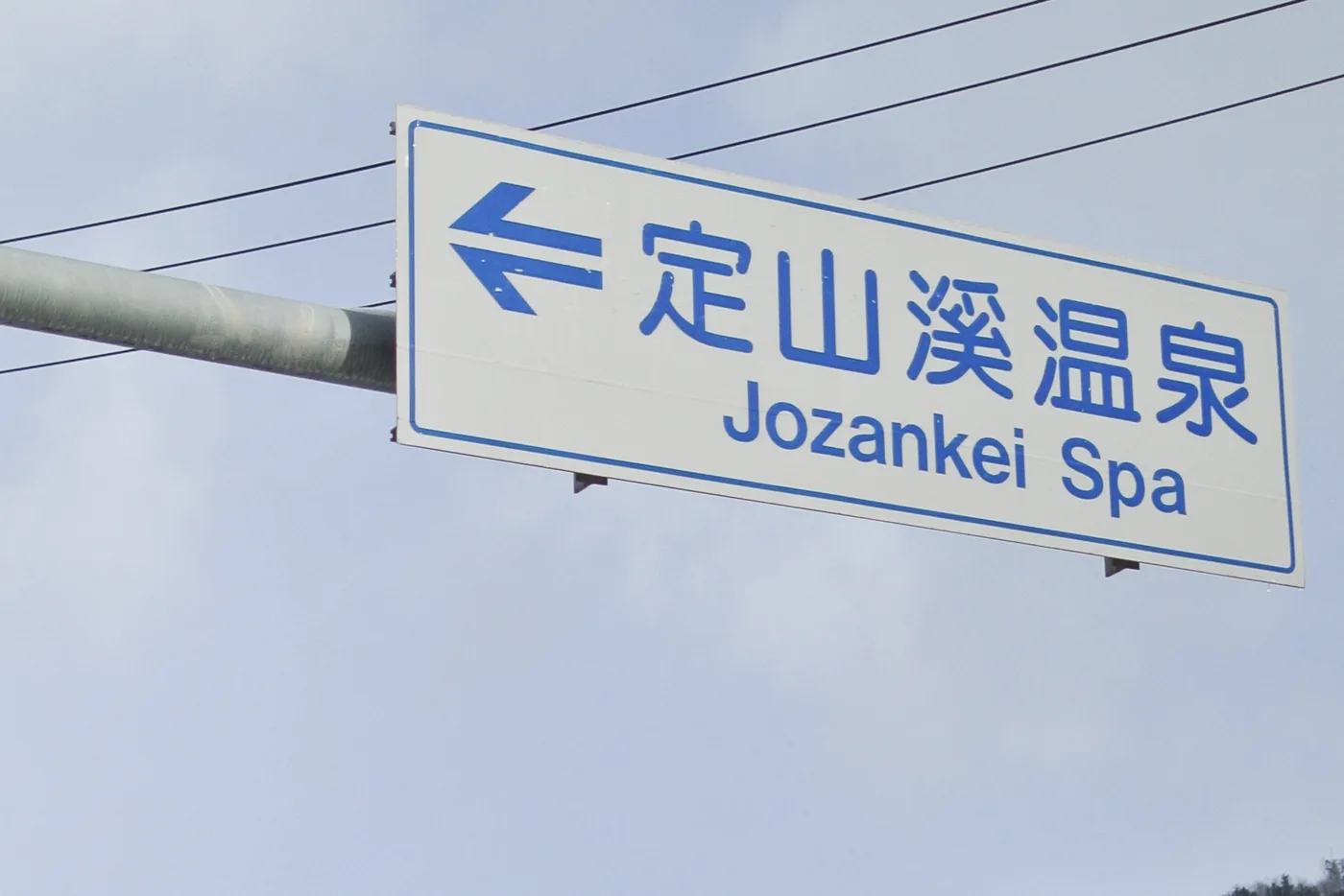 A snowy road with a sign pointing to Jozankei Spa, January 2018. Wikimedia Commons contributor photo, resized and cropped as WebP; not current conditions or a route to follow.